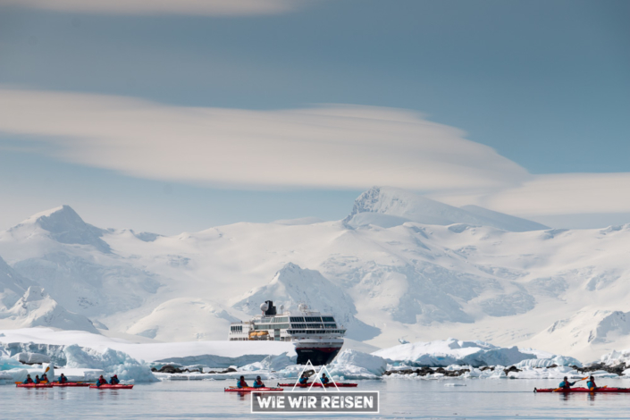 Kayaks inmitten der Eisberge der Antarktis mit der MS Midnatsol im Hintergrund