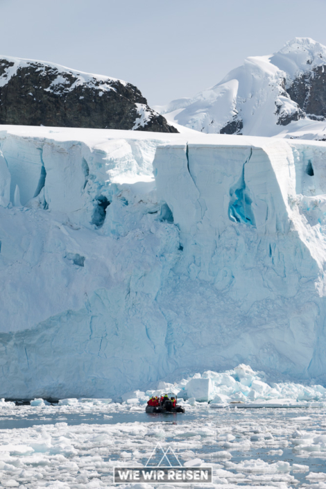 Massive Eiswand mit annähernden Hurtigruten Zodiacs
